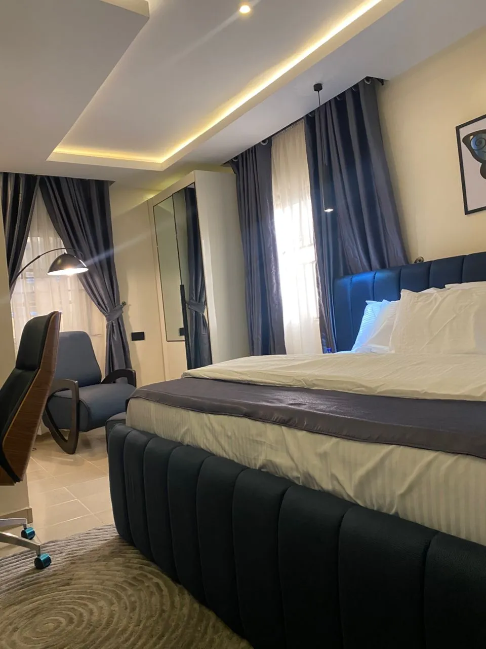 Dimple 44 premium king suite with blue velvet headboard and ambient lighting